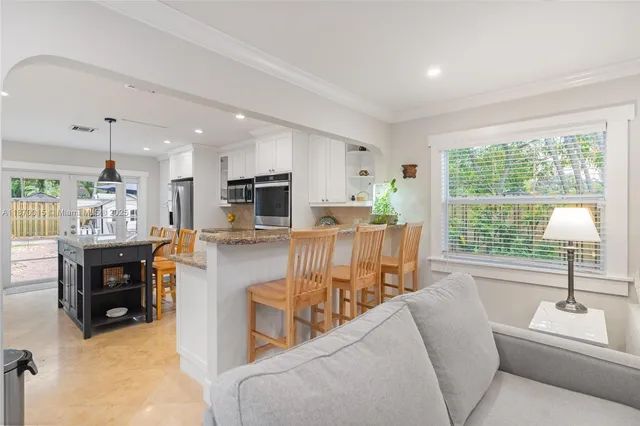 a living room with furniture a dining table and a large window