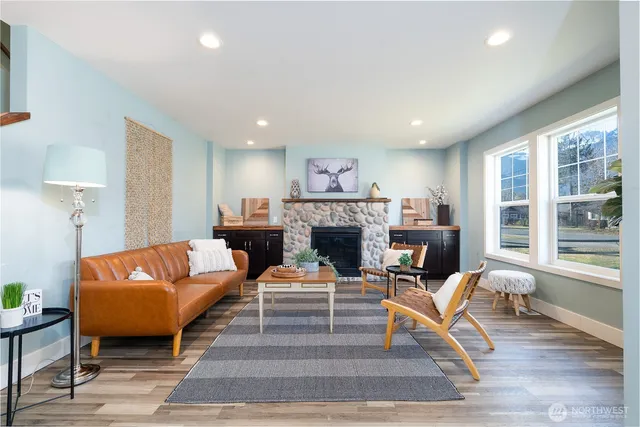 a living room with furniture a large window and a fireplace