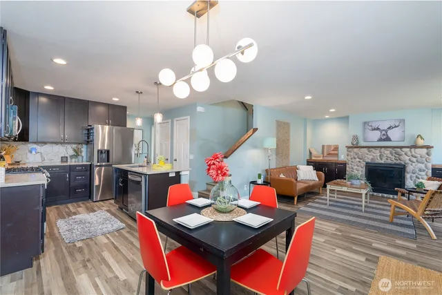 a living room with furniture kitchen view and a chandelier