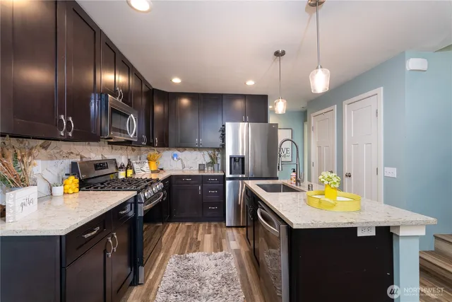 a kitchen with a refrigerator a sink a stove and wooden floor