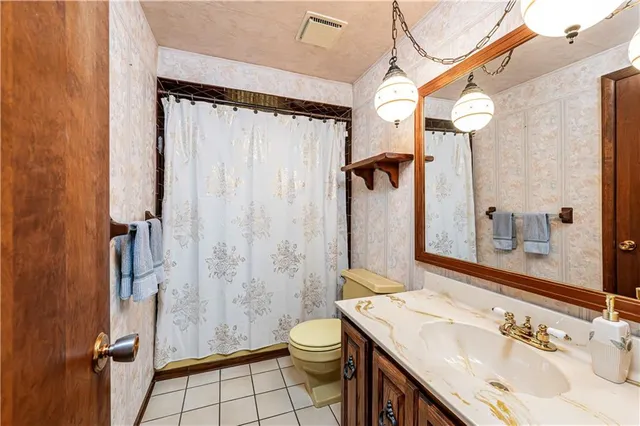 an empty room with windows and chandelier fan