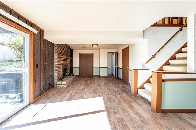 a view of a hallway with wooden floor and a fireplace