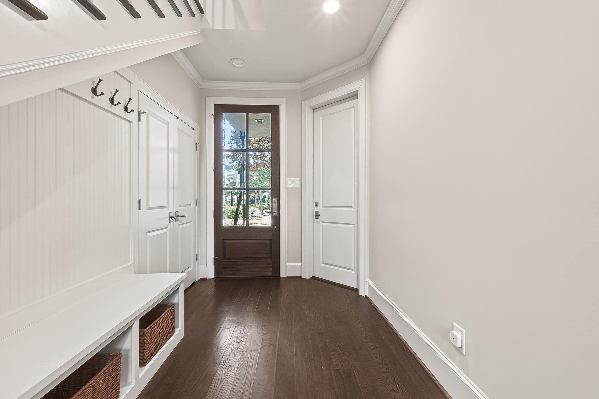 122 Gateway Park Place Spring, TX 77380 - Photo 5 of 44 Light-filled entry with upgraded wood flooring, built-in bench storage, and elegant crown molding.