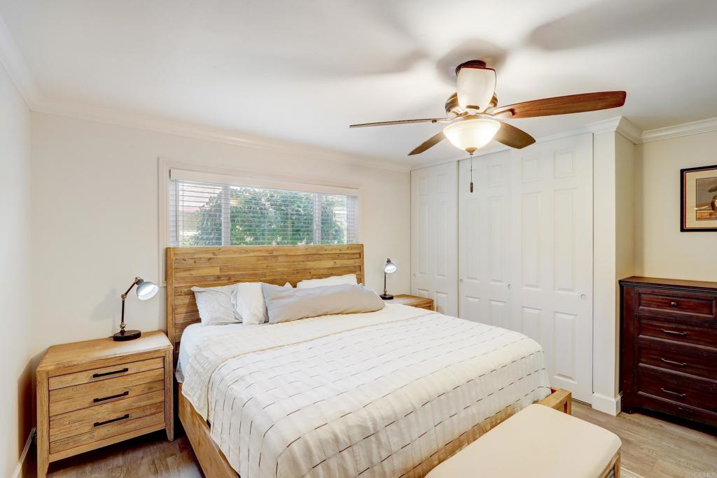 136 Hannalei Drive Vista, CA 92083 - Photo 16 of 32 a bedroom with a bed a dresser and a chandelier