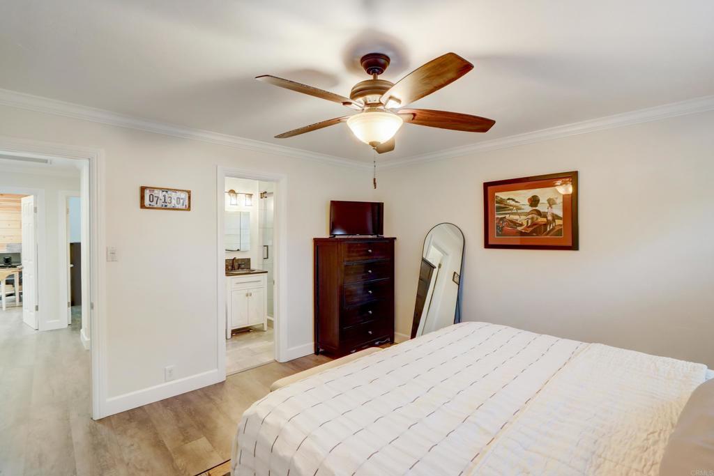 136 Hannalei Drive Vista, CA 92083 - Photo 17 of 32 a bedroom with a bed and a chandelier