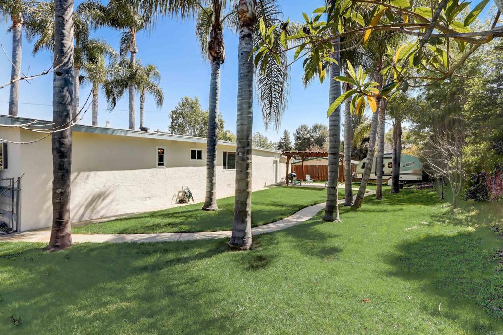 136 Hannalei Drive Vista, CA 92083 - Photo 20 of 32 a view of a white house in a big yard with palm trees