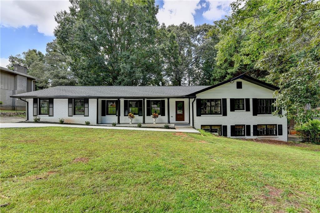 a front view of a house with a yard porch and wooden fence