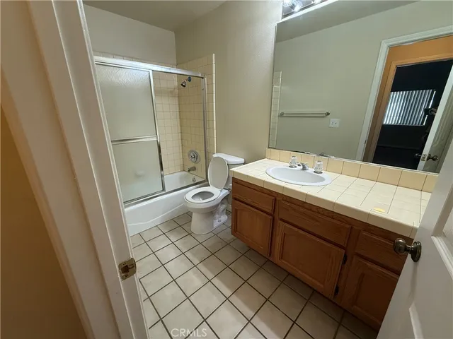 a bathroom with a sink a toilet a mirror and shower