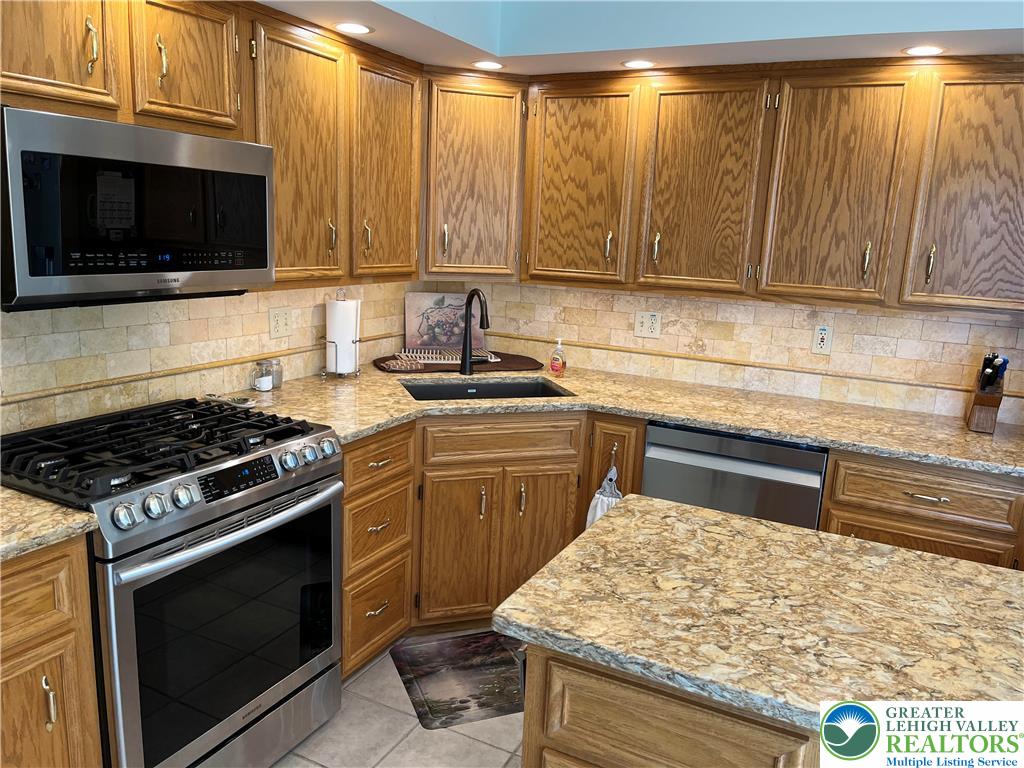 205 Spyglass Hill Road Bath, PA 18014 - Photo 10 of 51 a kitchen with granite countertop cabinets stainless steel appliances and a sink