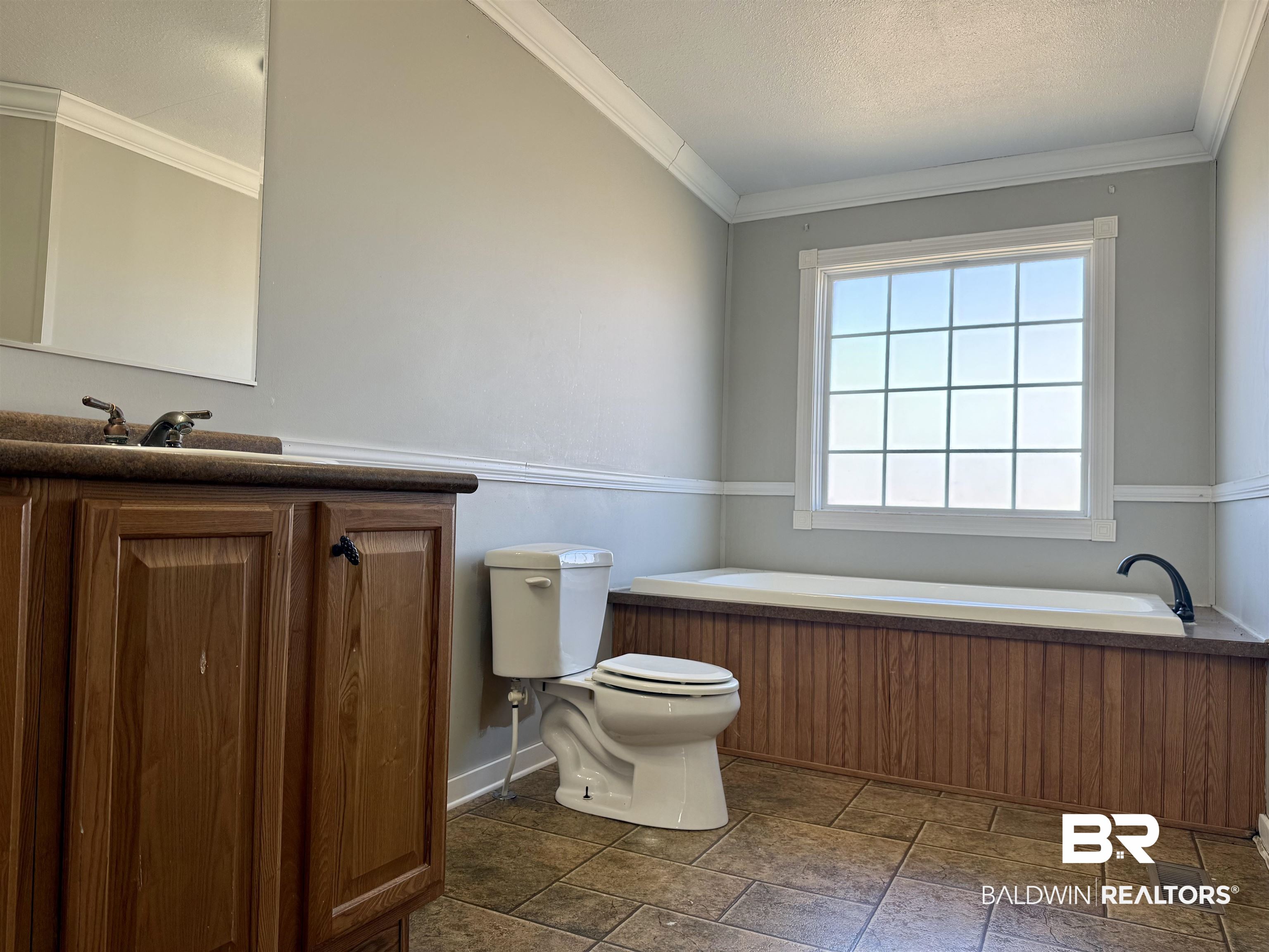 1064 Old Fannie Road Flomaton, AL 36441 - Photo 14 of 17 Full bath with crown molding, vanity, a garden tub, a textured ceiling, and dark stone finish floors