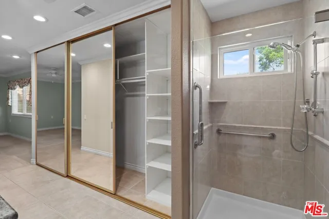 a bathroom with a glass shower door and a mirror