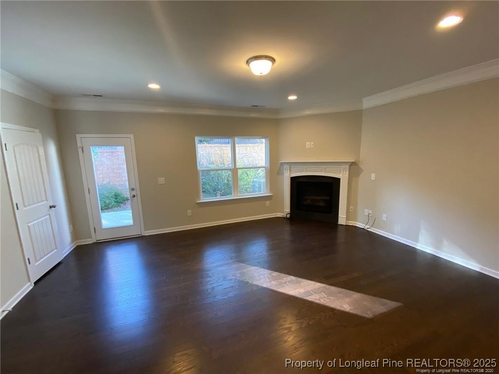 1206 Wingstem Place Raleigh, NC 27607 - Photo 12 of 17 an empty room with wooden floor fireplace and windows