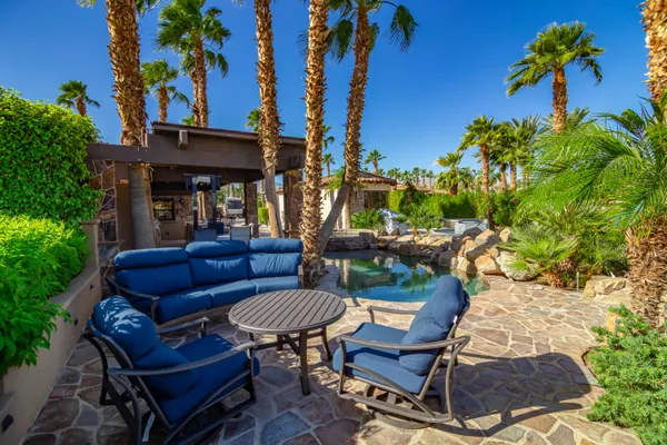 a view of backyard with outdoor seating a patio and plants