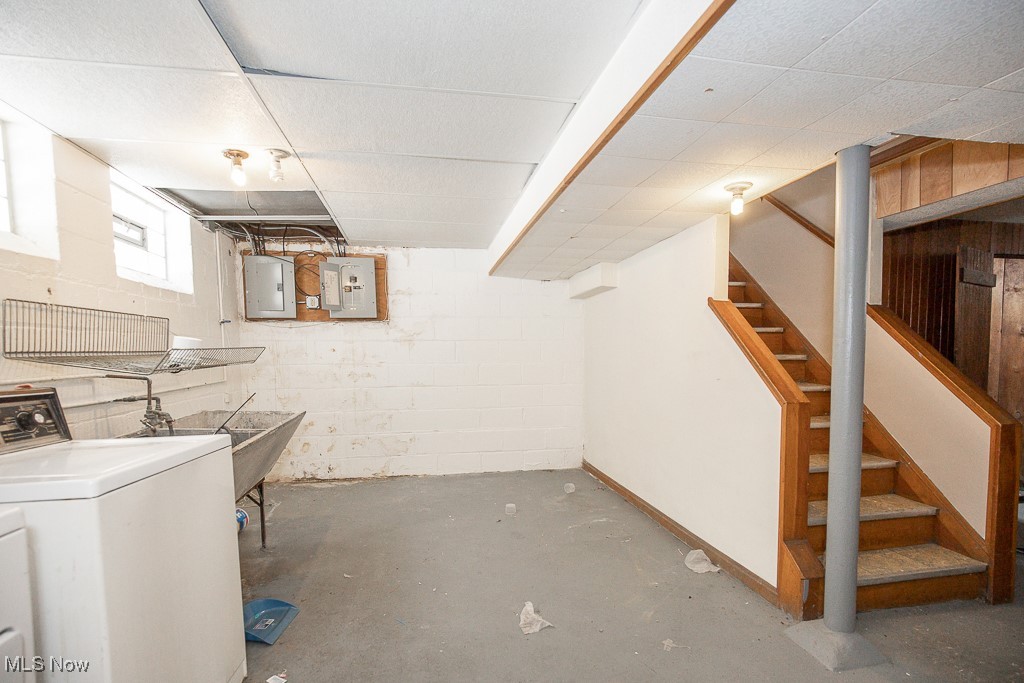 13545 Cedar Road Cleveland, OH 44118 - Photo 28 of 41 Basement featuring concrete block wall, washer / dryer, electric panel, a drop ceiling, and stairs