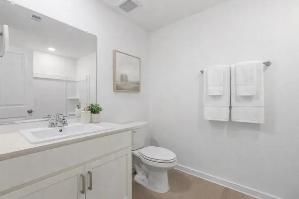 a bathroom with a sink a toilet and mirror