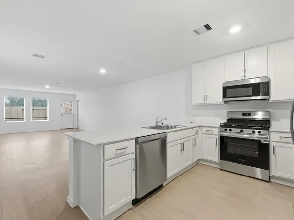 a kitchen with stainless steel appliances granite countertop a stove and a sink