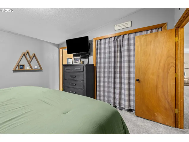 a bedroom with a bed and a flat screen tv