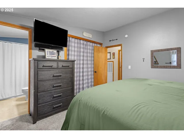 a bedroom with a bed and a flat screen tv