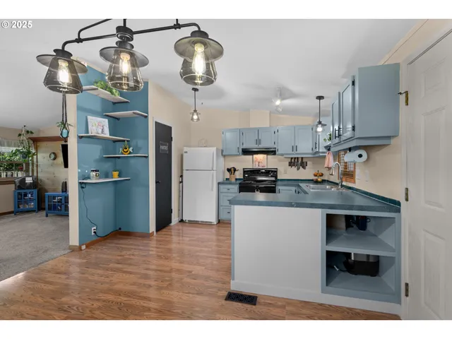 a kitchen with stainless steel appliances granite countertop a refrigerator a stove and a wooden floors