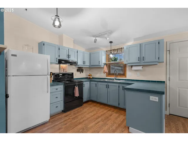 a kitchen with stainless steel appliances granite countertop a refrigerator a stove a sink dishwasher and a refrigerator