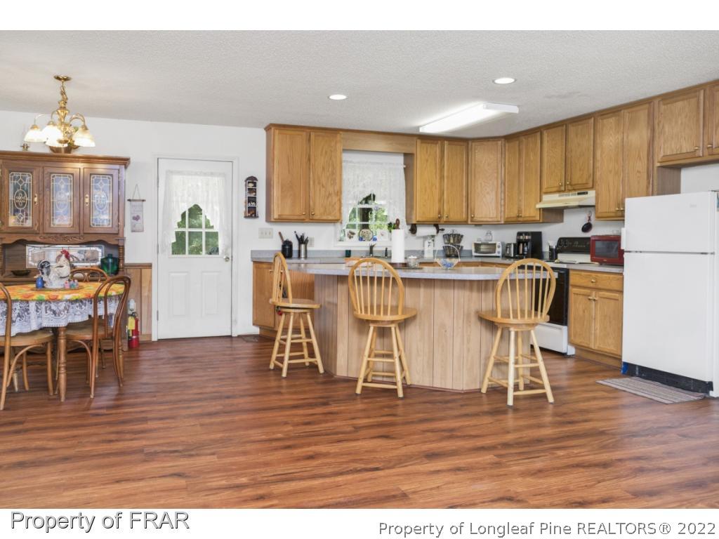 5253 Lobelia Road Vass, NC 28394 - Photo 11 of 28 a view of a dining room with furniture and wooden floor