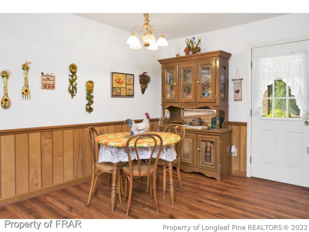 5253 Lobelia Road Vass, NC 28394 - Photo 14 of 28 a view of a dining room with furniture and wooden floor