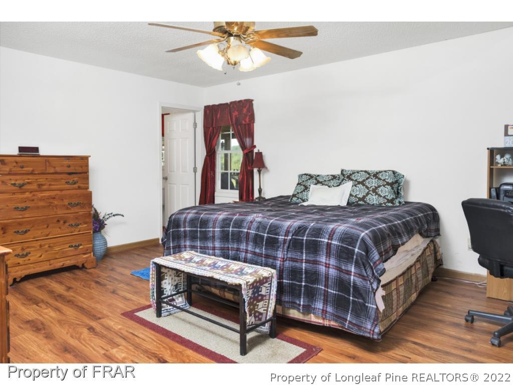 5253 Lobelia Road Vass, NC 28394 - Photo 15 of 28 a bedroom with a bed and wooden floor