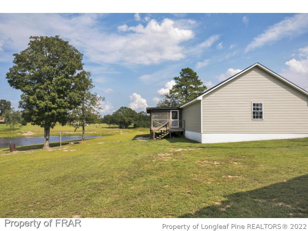 5253 Lobelia Road Vass, NC 28394 - Photo 27 of 28 a house view with swimming pool and trees