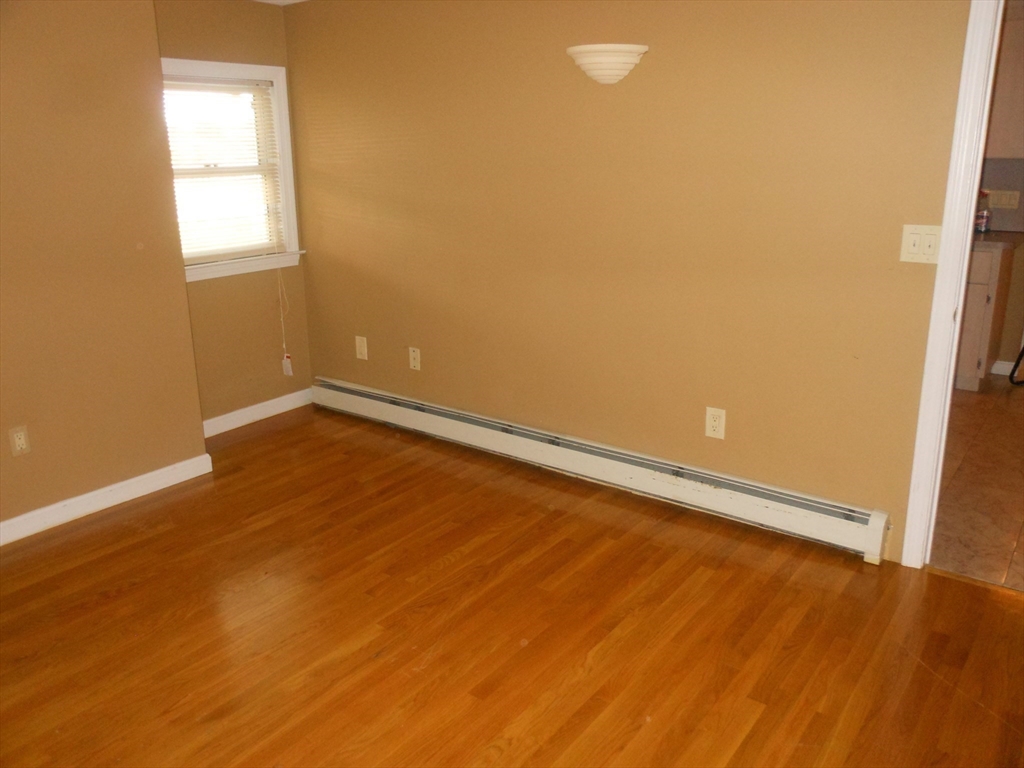 21 Cook, Unit 1 Chelsea, MA 02150 - Photo 30 of 32 an empty room with wooden floor and windows