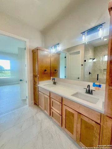 a bathroom with double vanity sinks and a mirror