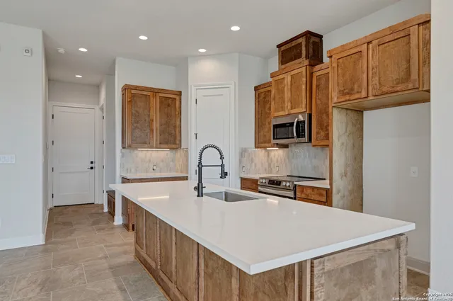 a kitchen with stainless steel appliances granite countertop a sink a stove and a refrigerator