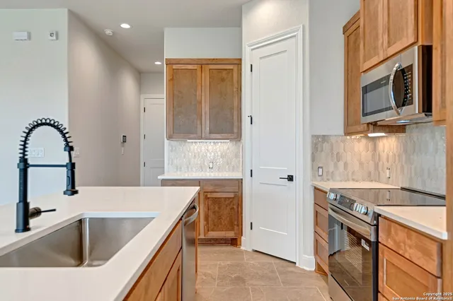 a kitchen with a sink cabinets and stainless steel appliances