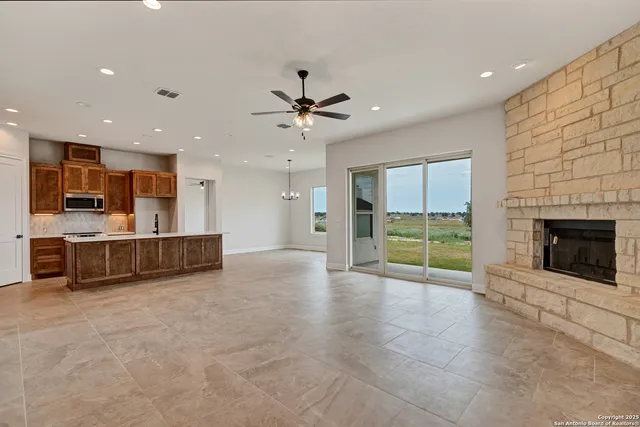 a view of an empty room with a fireplace and a window