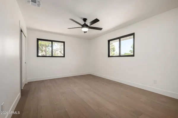 an empty room with windows and fan