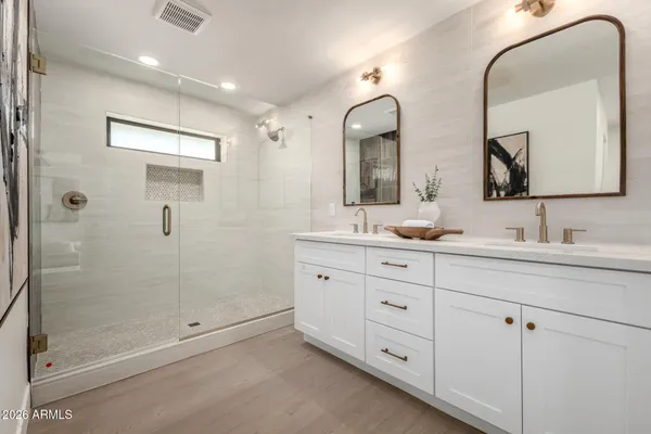 a bathroom with double sink and a mirror