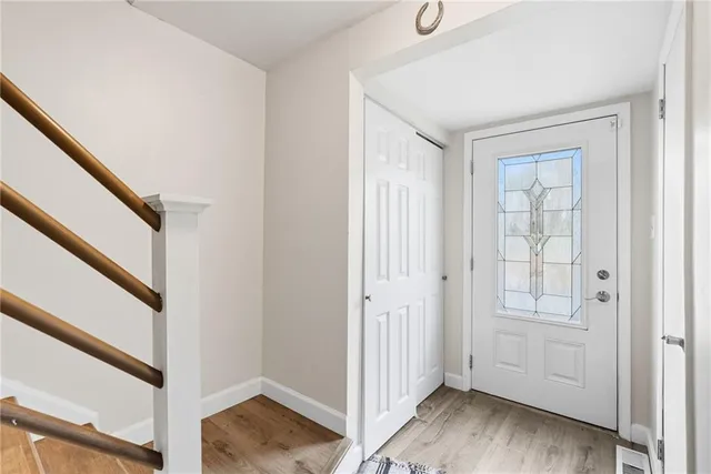 a view of a hallway with wooden floor and entryway