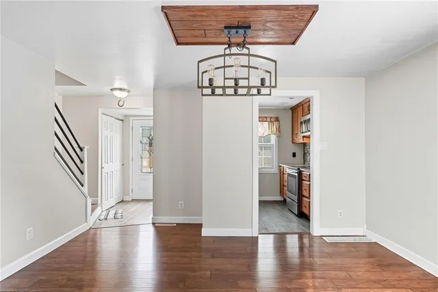 a view of a livingroom with wooden floor and staircase