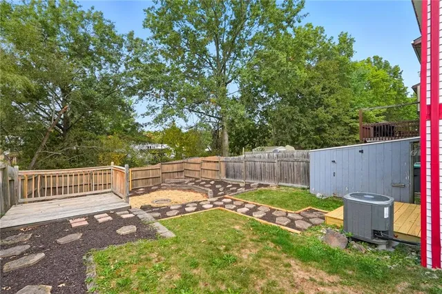 a view of a backyard with a small cabin and wooden fence