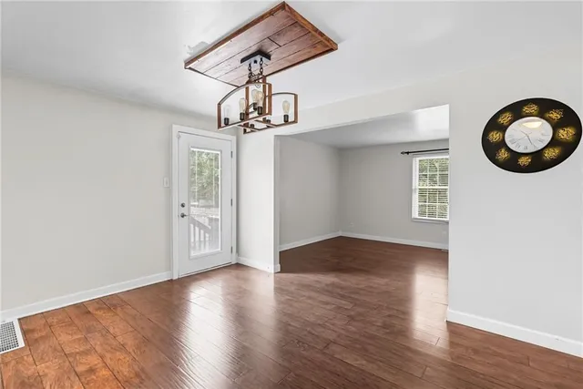 a view of a room with wooden floor and chandelier