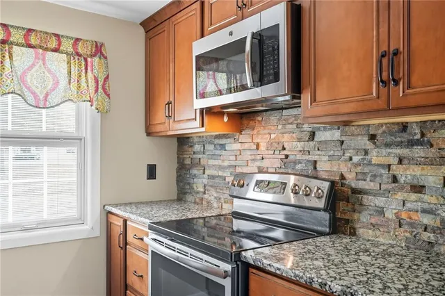 a kitchen with stainless steel appliances granite countertop a stove and a microwave