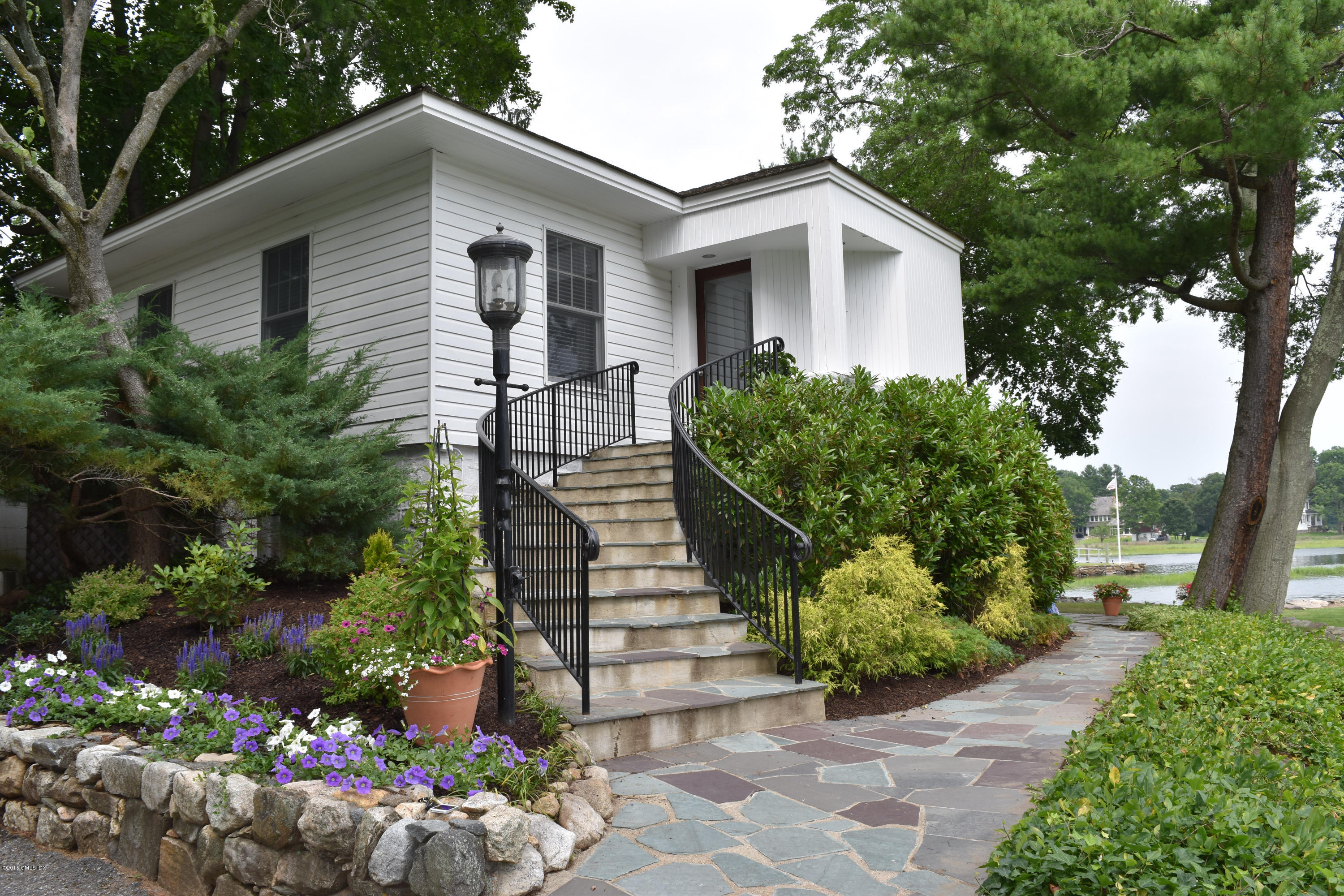 25 Willowmere Avenue Riverside, CT 06878 - Photo 1 of 12 a front view of a house with a yard and a garden
