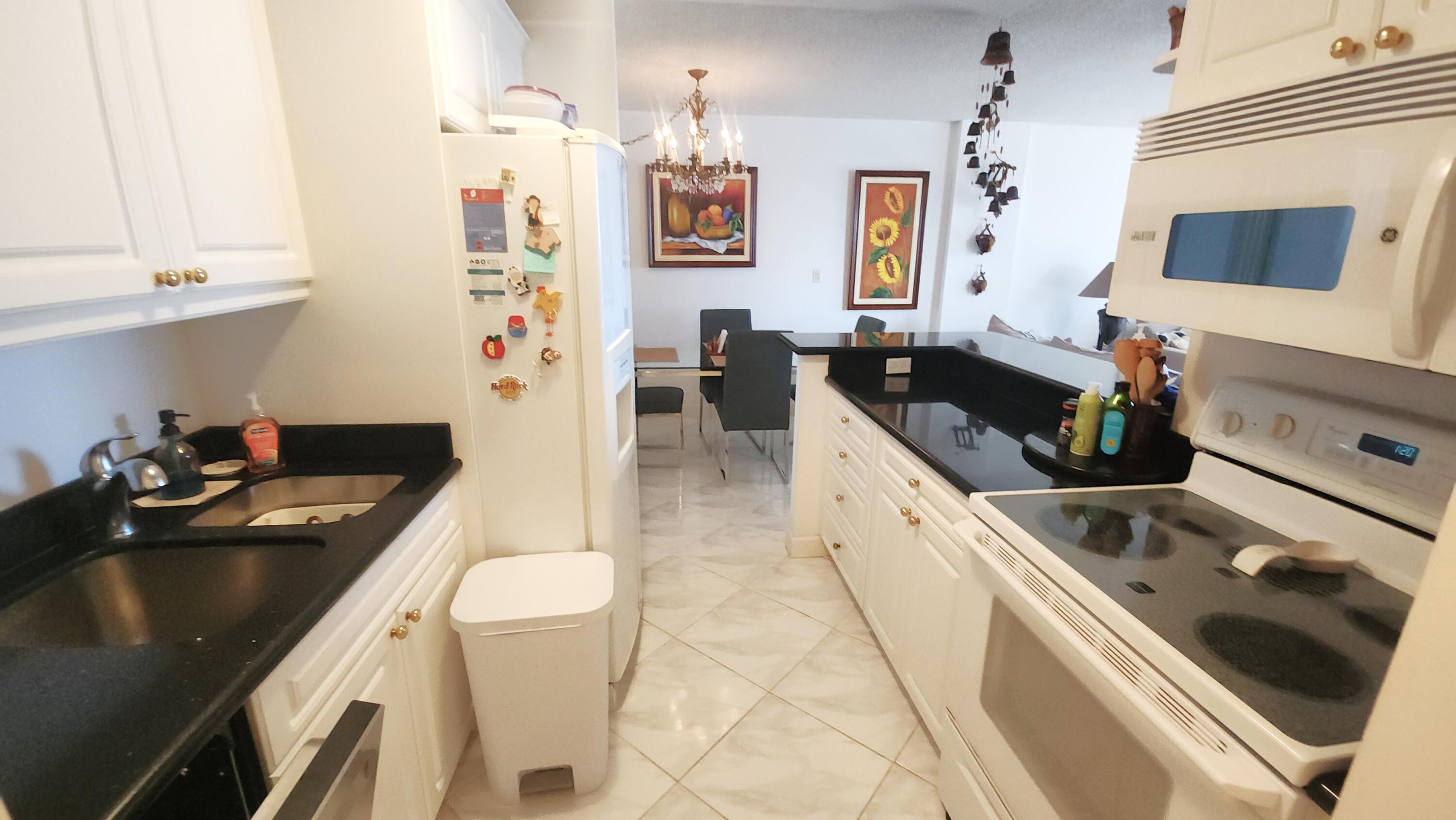 2121 North Ocean Boulevard, Unit 1205E Boca Raton, FL 33431 - Photo 12 of 54 a kitchen with a sink stove and refrigerator