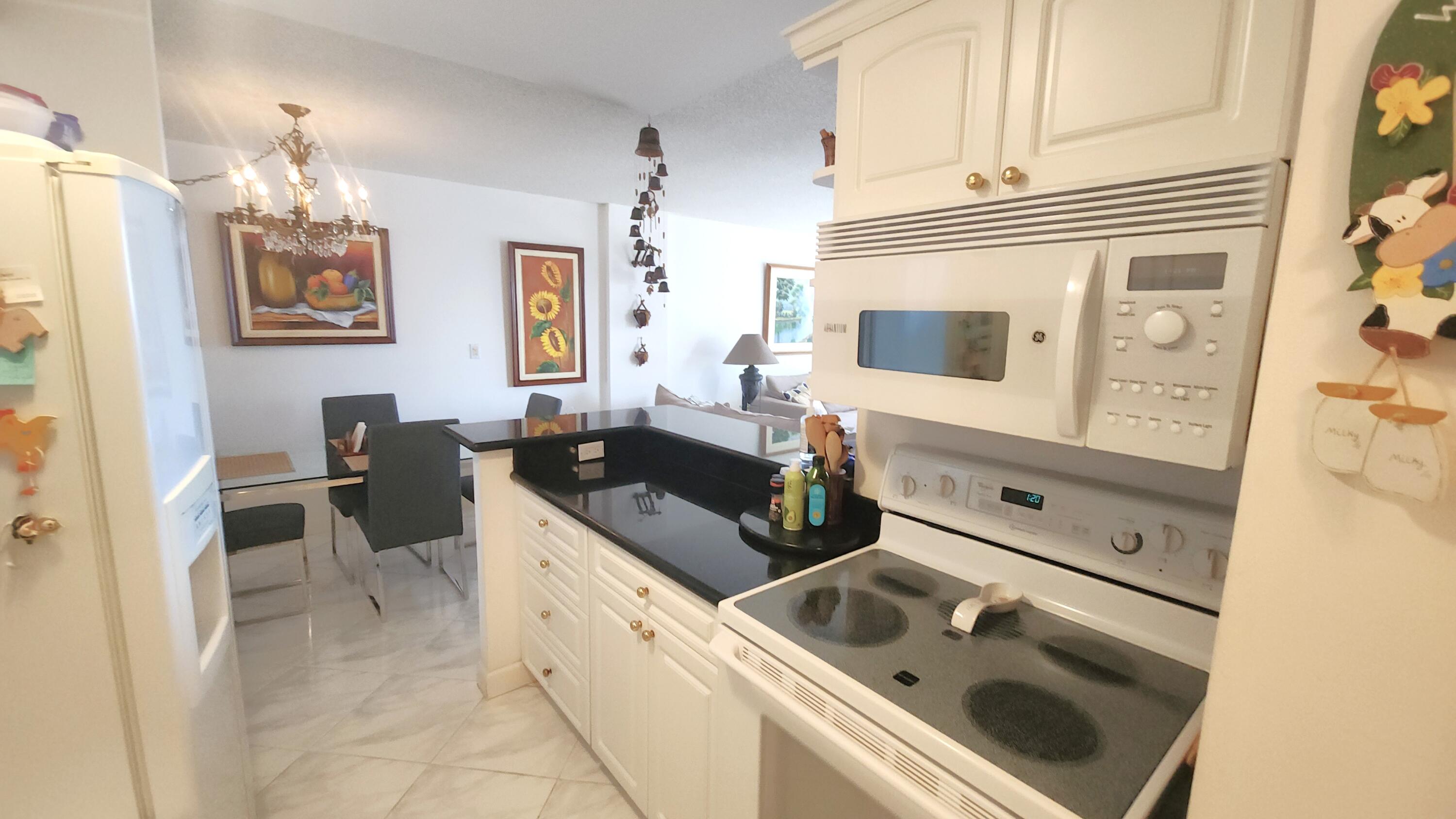2121 North Ocean Boulevard, Unit 1205E Boca Raton, FL 33431 - Photo 13 of 54 a kitchen with a sink stove and cabinets