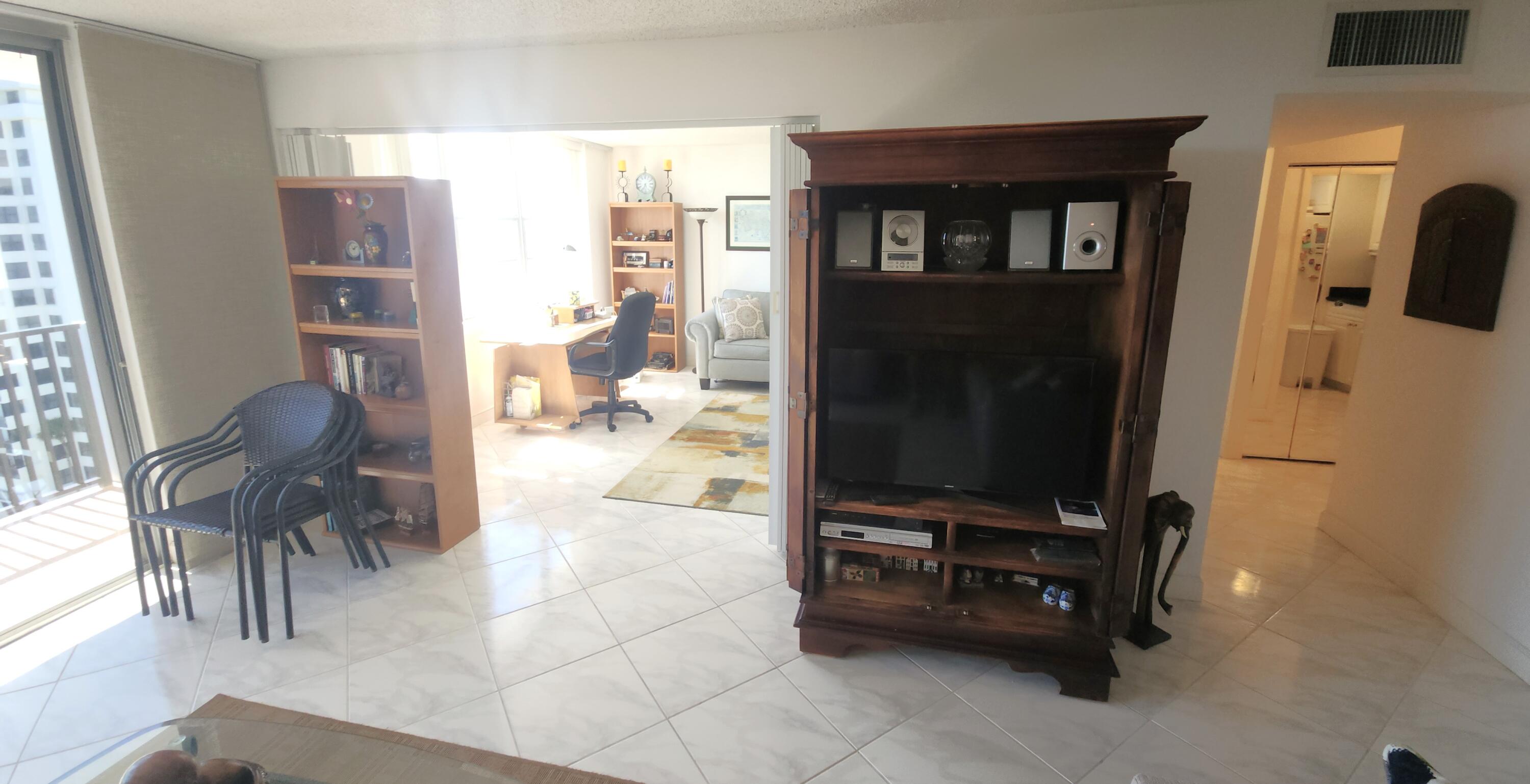 2121 North Ocean Boulevard, Unit 1205E Boca Raton, FL 33431 - Photo 16 of 54 a living room with furniture a flat screen tv and a refrigerator