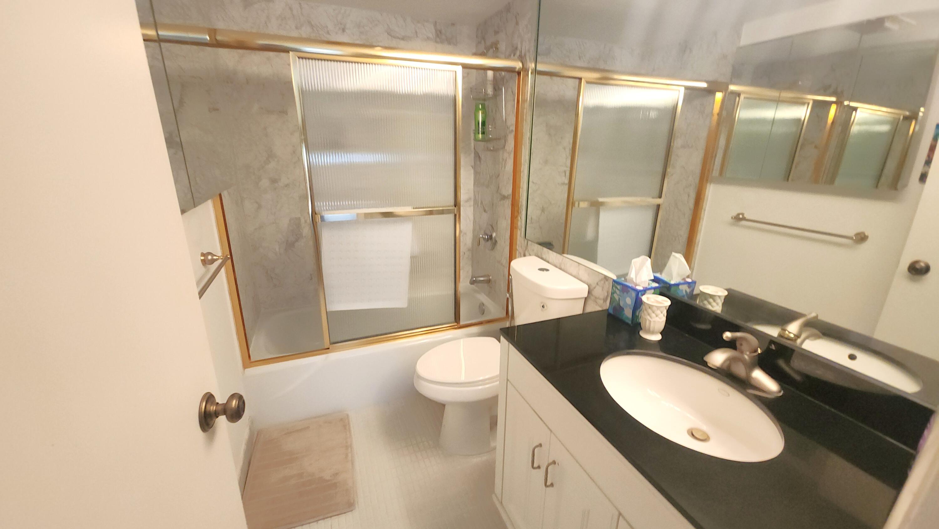 2121 North Ocean Boulevard, Unit 1205E Boca Raton, FL 33431 - Photo 20 of 54 a bathroom with a granite countertop sink toilet and shower