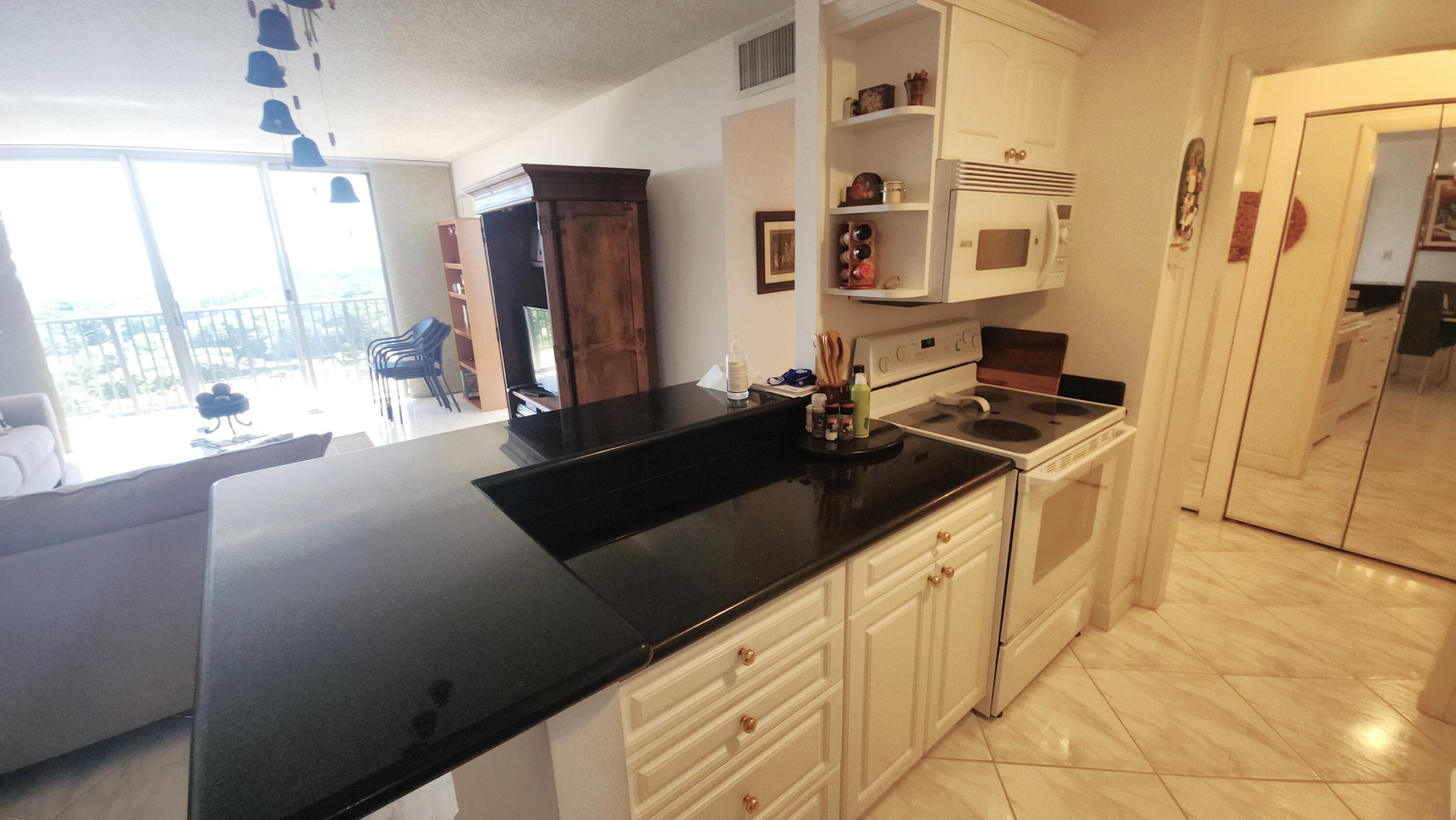 2121 North Ocean Boulevard, Unit 1205E Boca Raton, FL 33431 - Photo 10 of 54 a kitchen with stainless steel appliances a sink stove and refrigerator
