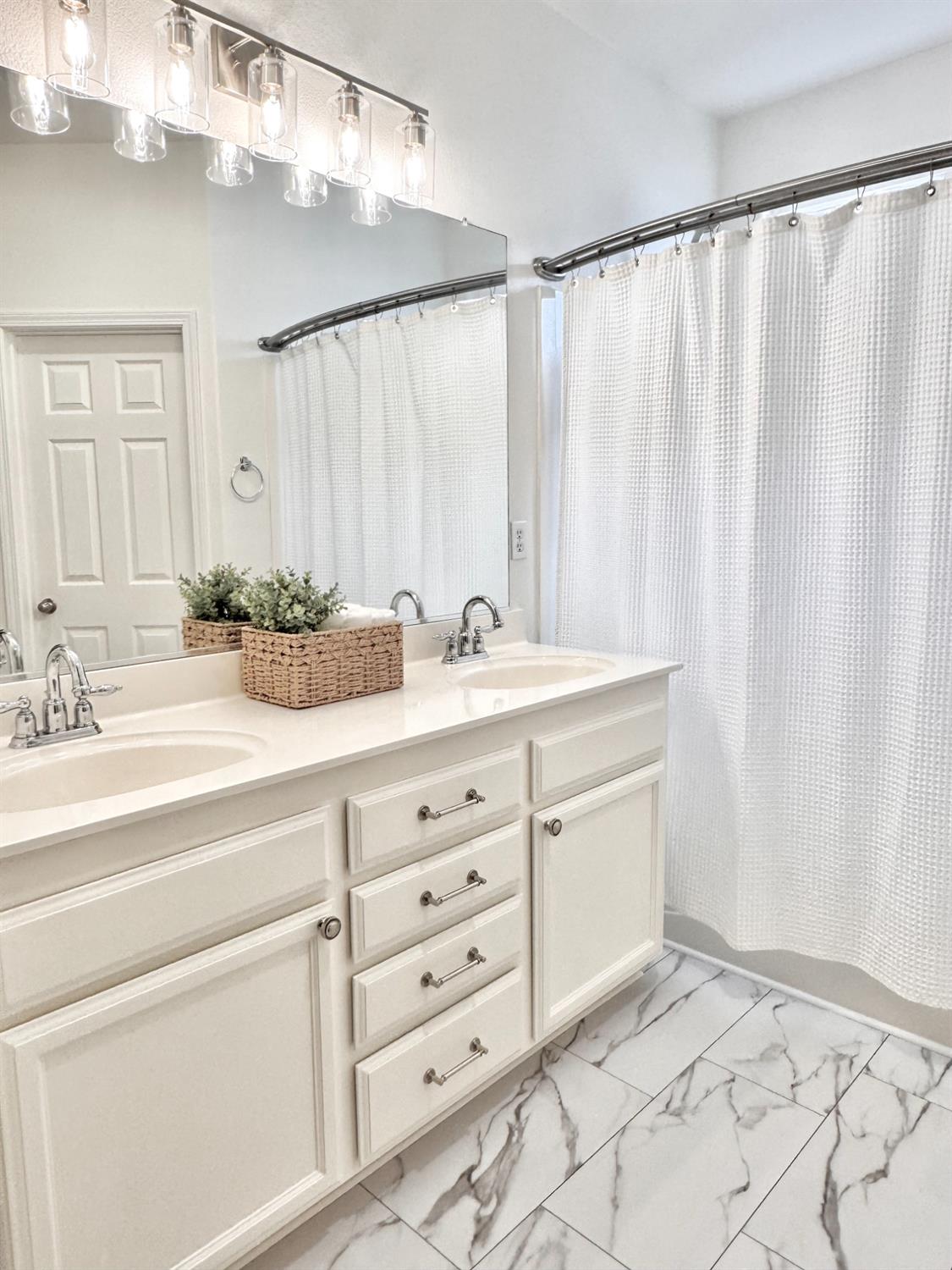 12372 Pawcatuck Way Rancho Cordova, CA 95742 - Photo 19 of 48 a bathroom with a double vanity sink and a mirror