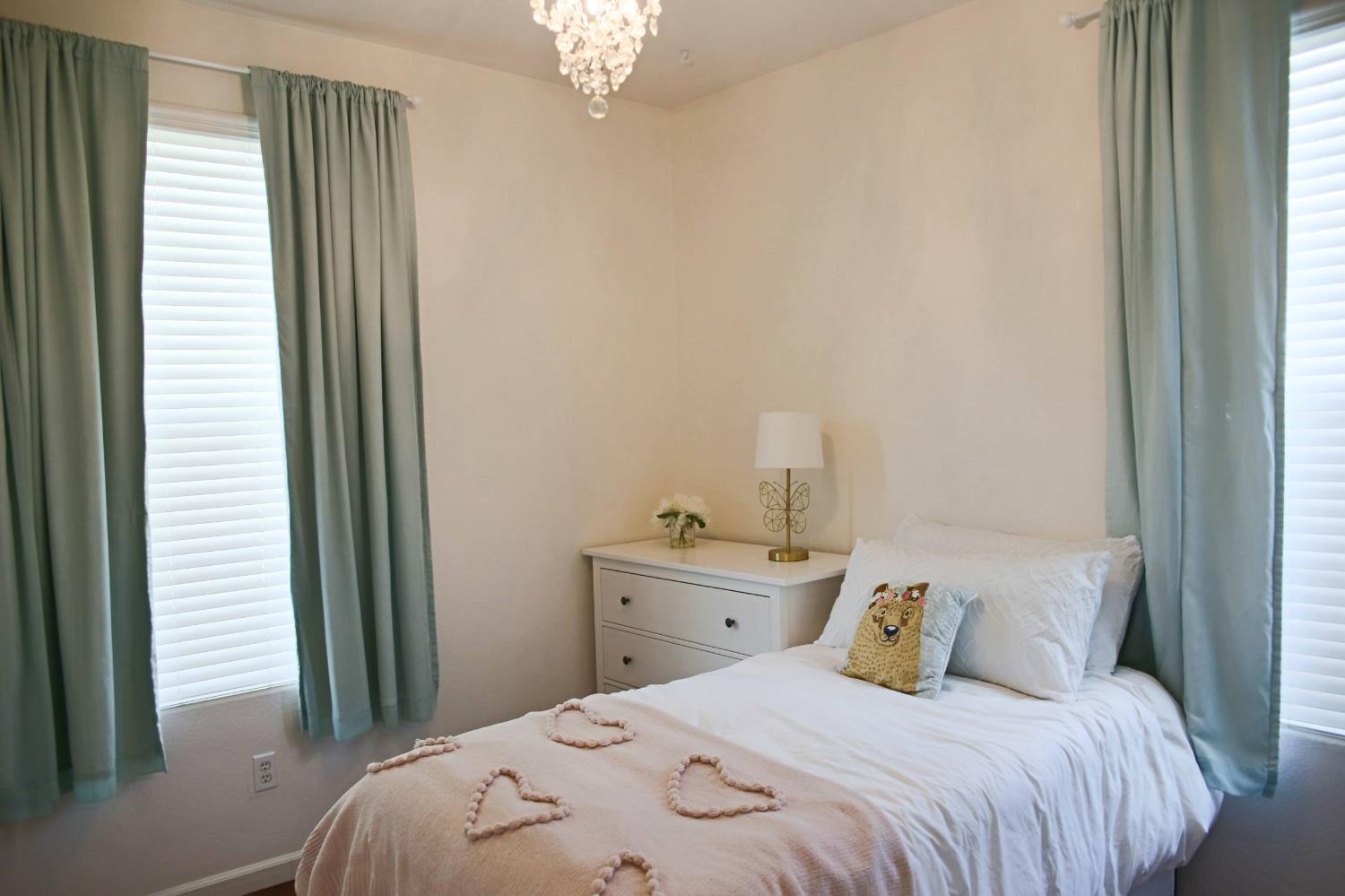 12372 Pawcatuck Way Rancho Cordova, CA 95742 - Photo 26 of 48 a bedroom with a bed and a chandelier