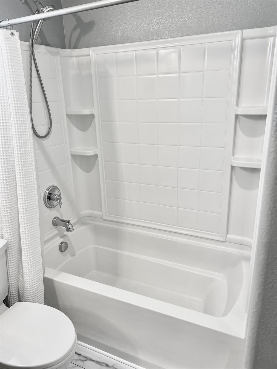 12372 Pawcatuck Way Rancho Cordova, CA 95742 - Photo 29 of 48 a bathroom with a bathtub and a shower