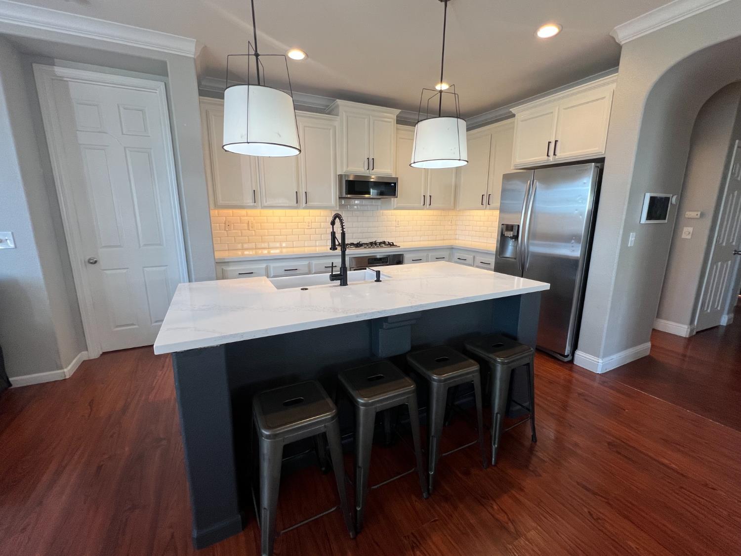 12372 Pawcatuck Way Rancho Cordova, CA 95742 - Photo 7 of 48 a kitchen with stainless steel appliances a table chairs refrigerator and microwave